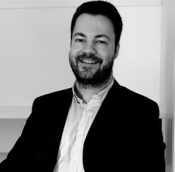 John Isufi, the author of Upward Dynamism, with the mission to democratize practical AI knowledge.